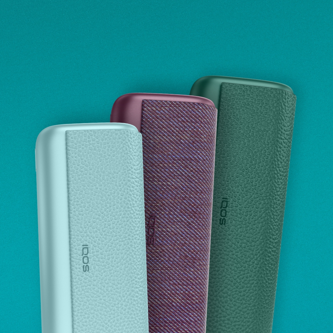 Três dispositivos IQOS ILUMA i PRIME dispostos na vertical na cor azul claro, vermelho escuro e verde, sobre um fundo turquesa.