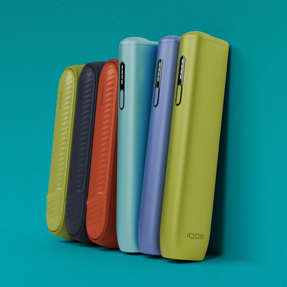 Cinco dispositivos IQOS ILUMA i na cor verde, azul escuro, terracota e IQOS ILUMA i ONE na cor azul claro, violeta e verde dispostos na vertical, sobre um fundo turquesa.