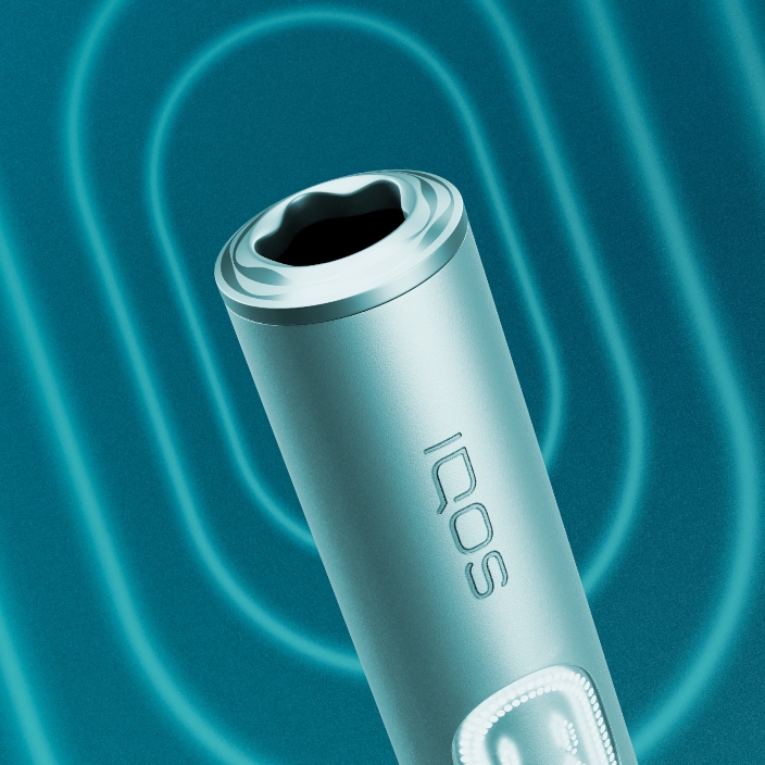 Detalhe de equipamento IQOS ILUMA i PRIME azul claro, aro e luzes de presença do dispositivo, em fundo azul com efeito luminoso