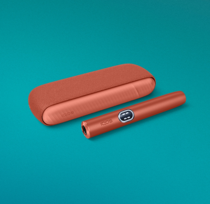 Equipamento IQOS ILUMA i terracota, orientado para a direita, sobre fundo azul