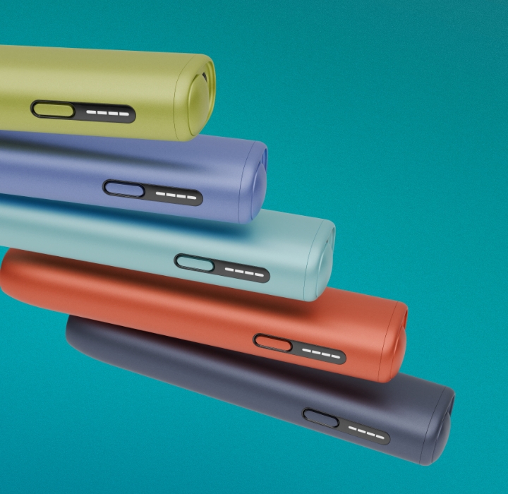 Detalhe de cinco equipamentos IQOS ILUMA i ONE na cor verde, violeta, azul claro, terracora e azul escuro, com detalhe das luzes de presença, orientados para direita sobre fundo azul