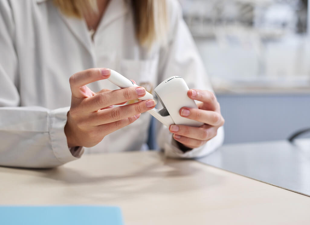 Técnica de laboratório a segurar o IQOS