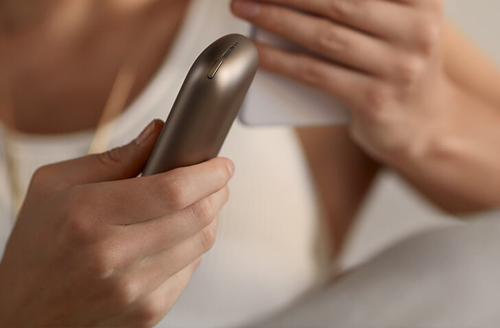 Person holding an iqos device