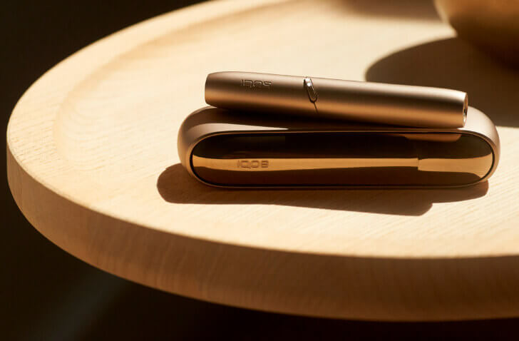 Iqos gold device on top of a wooden table