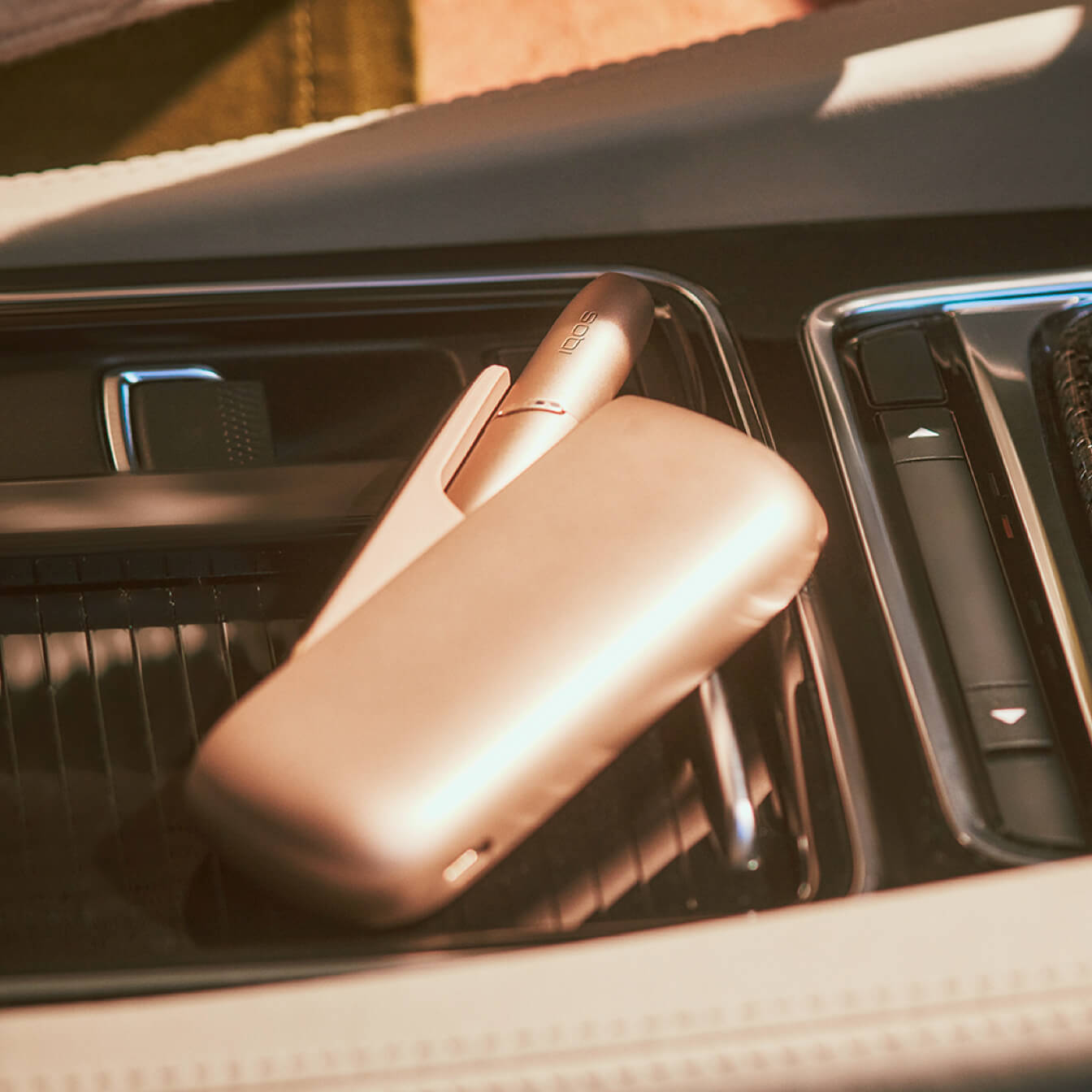 Um IQOS 3 DUO na consola central de um carro.