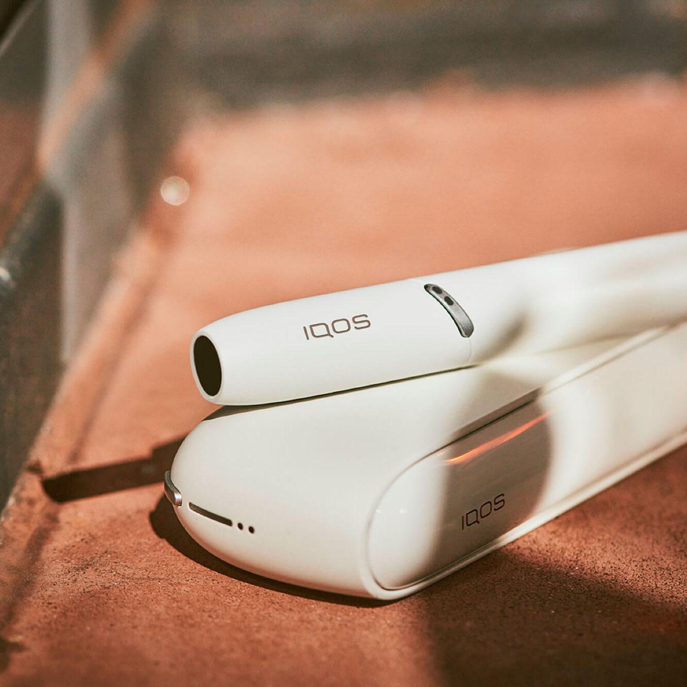 Um IQOS 3 DUO branco ao sol.