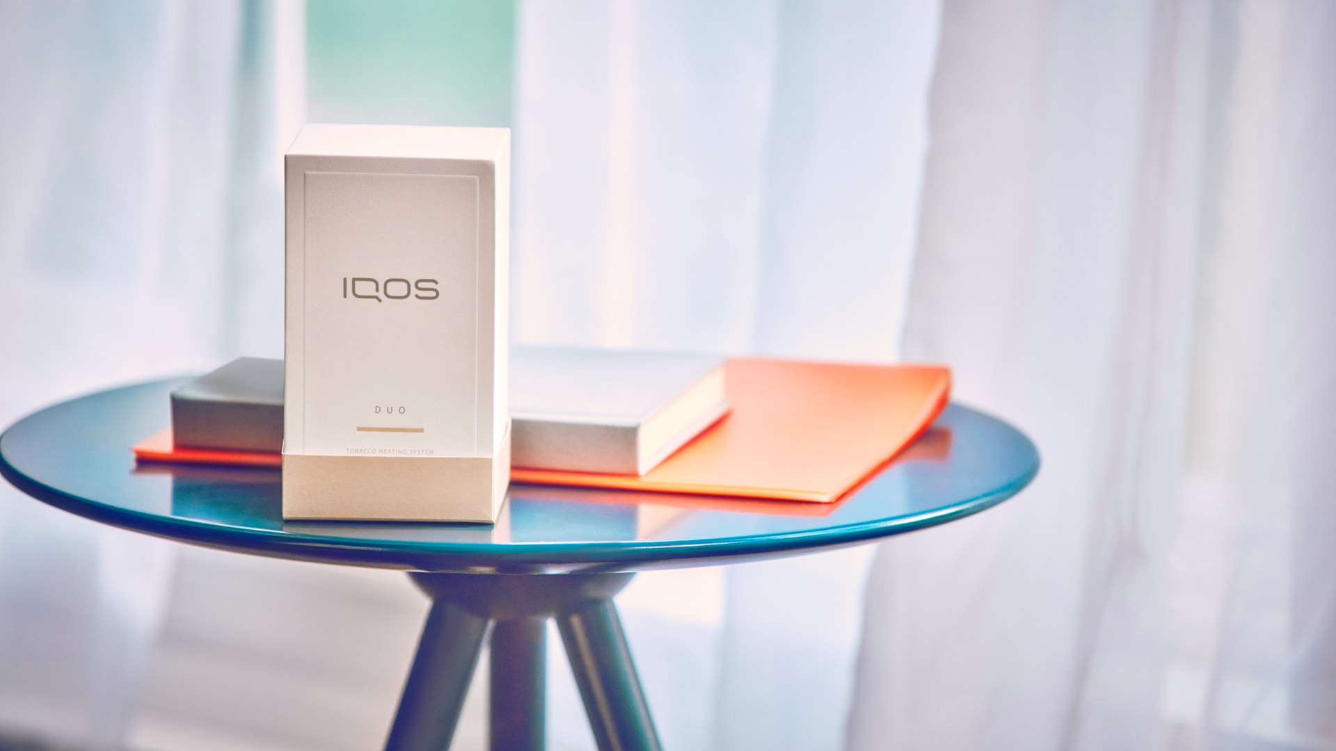 Embalagem IQOS sobre uma mesa de vidro