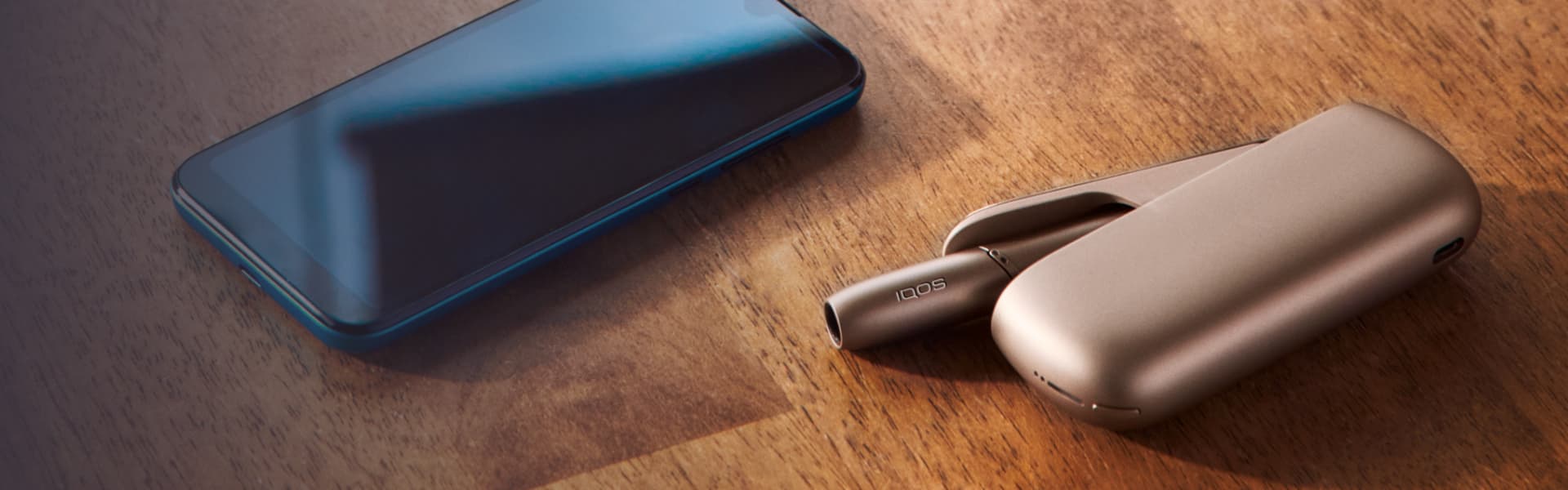 An IQOS device and a mobile on a table