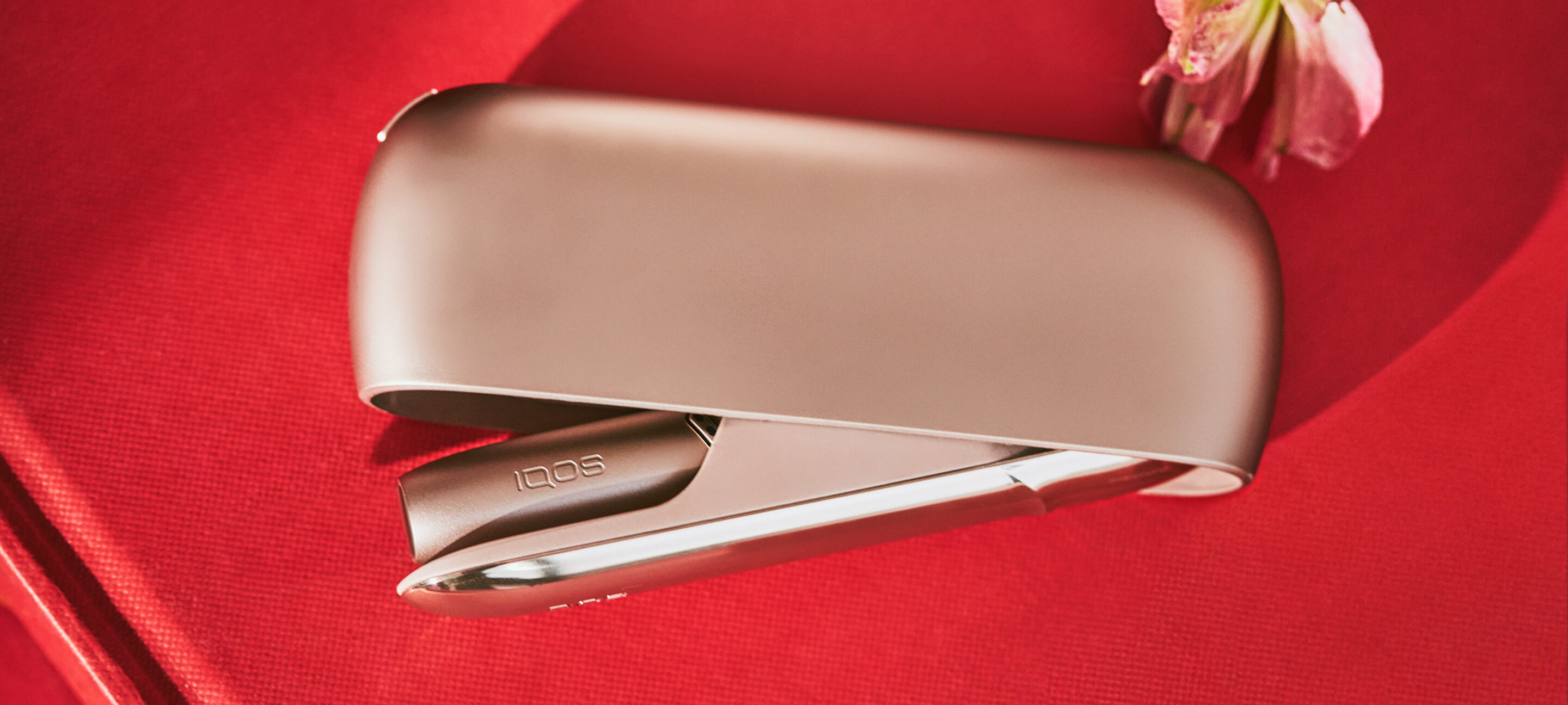 Um IQOS 3 DUO sobre um fundo vermelho
