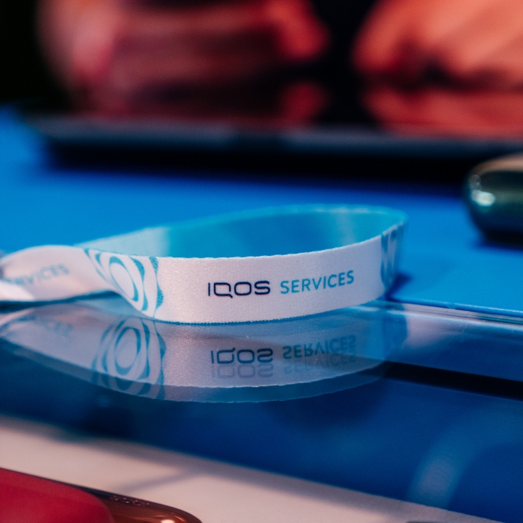 pulseira com o logo da IQOS em cima de uma mesa