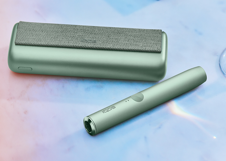 IQOS 3 DUO holder and charger on a dinner table