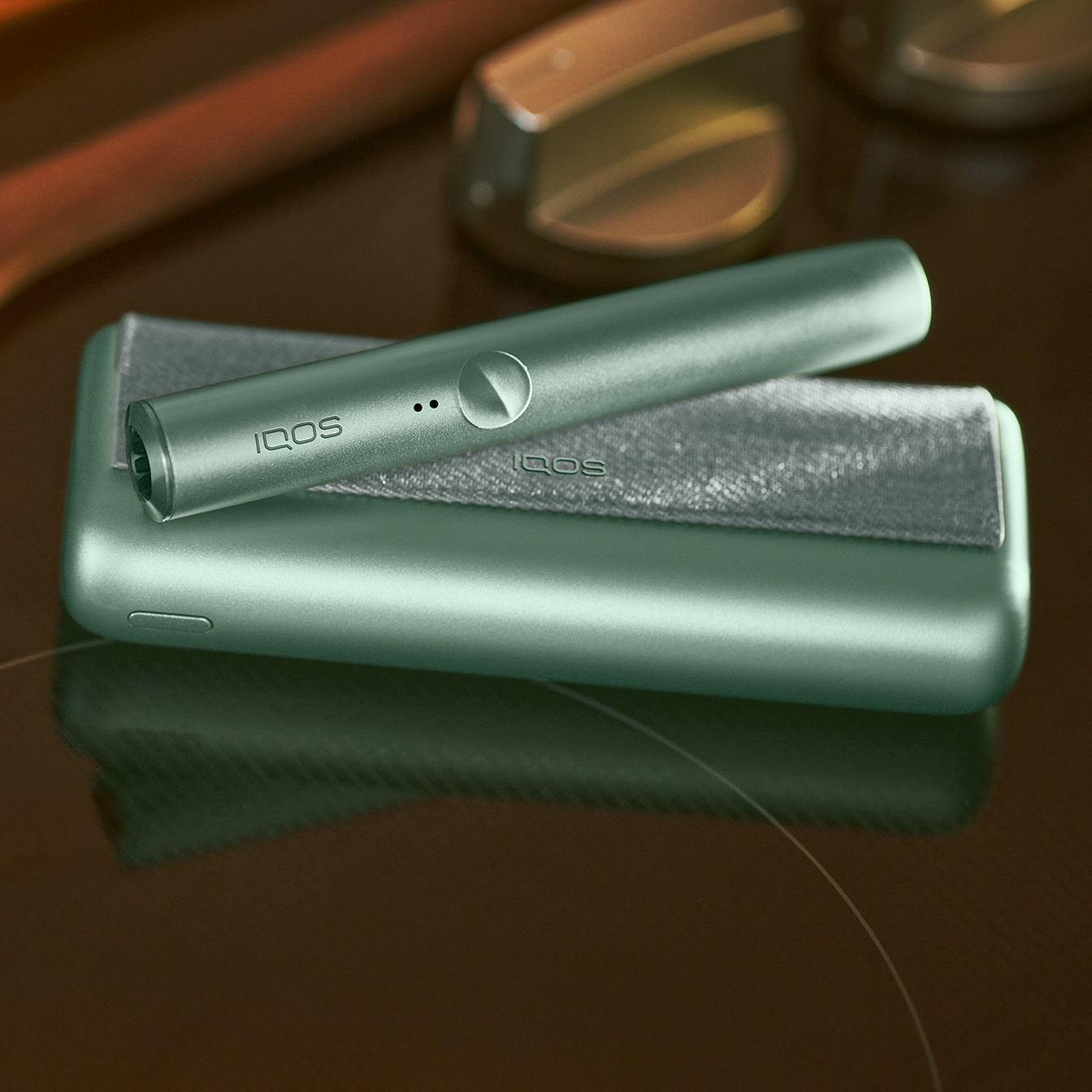 Brilliant gold IQOS 3 DUO holder inserted on fabric with red stars