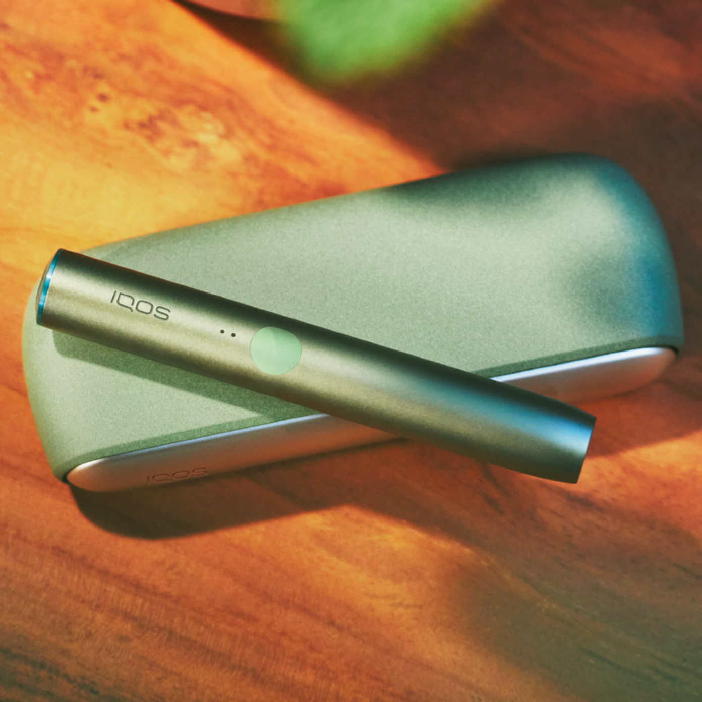 Cups, an IQOS device and a mobile on a table
