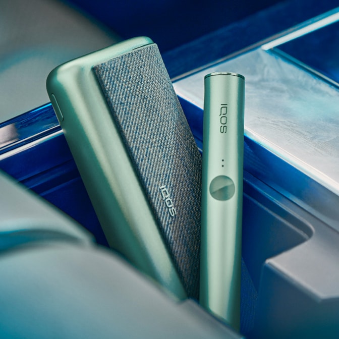 Um carregador de bolso e um dispositivo IQOS ILUMA PRIME verde.