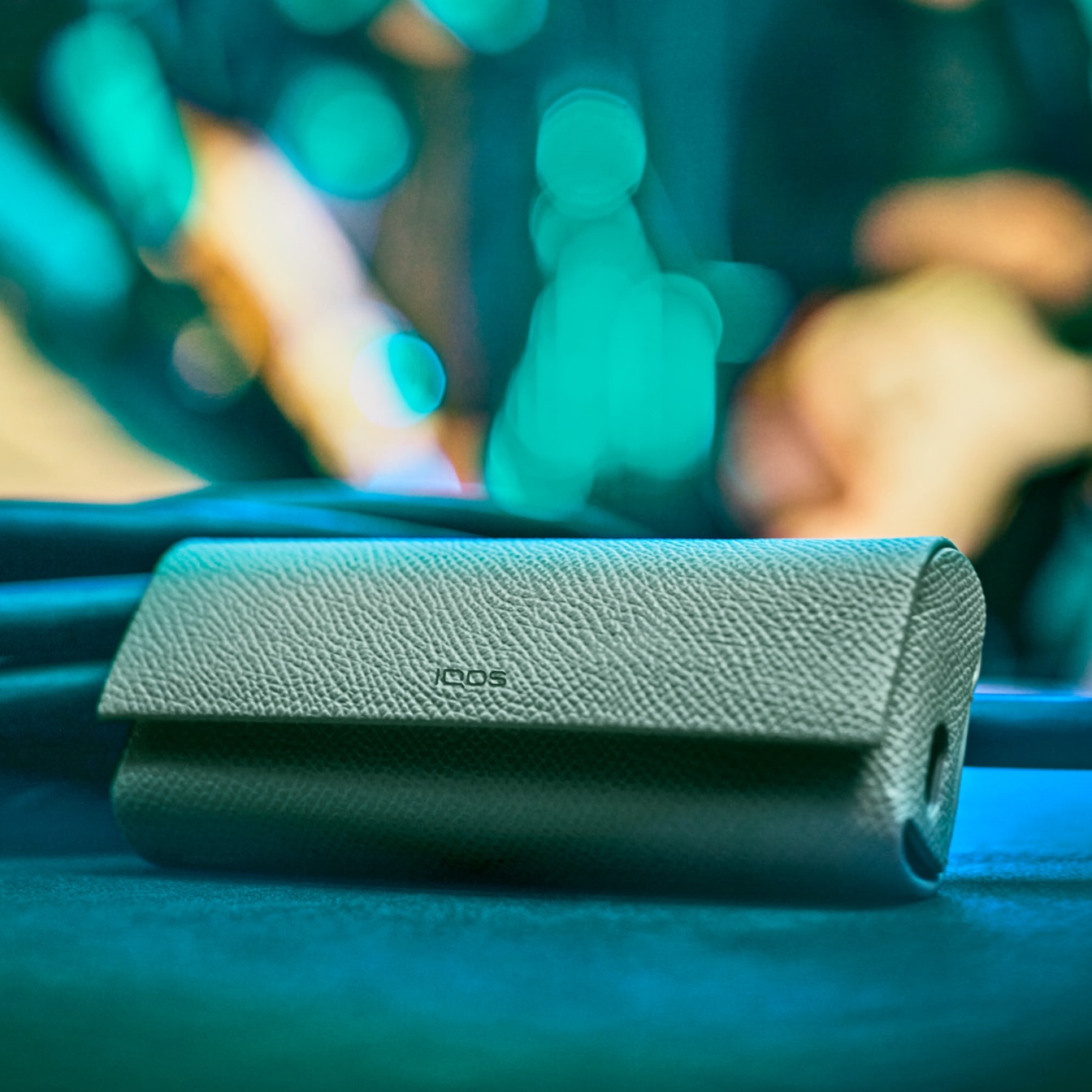 Um dispositivo e carregador de bolso IQOS ILUMA PRIME verde.