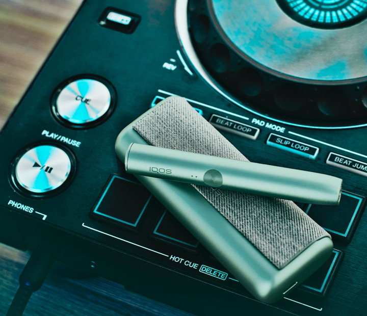 Dispositivo e carregador de bolso ILUMA PRIME verde sobre um gira-discos.