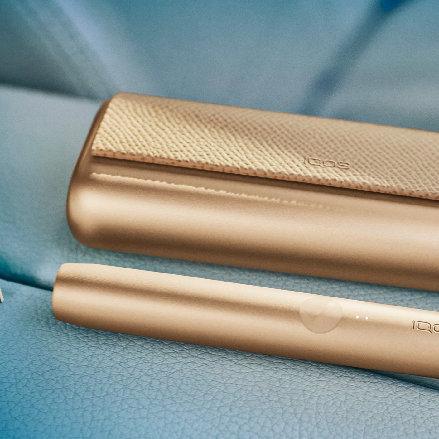 Um Carregador de Bolso e um Dispositivo IQOS ILUMA PRIME Dourado Caqui