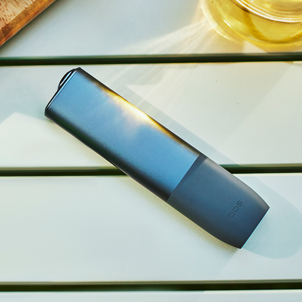 An IQOS ILUMA device and mobile phone.