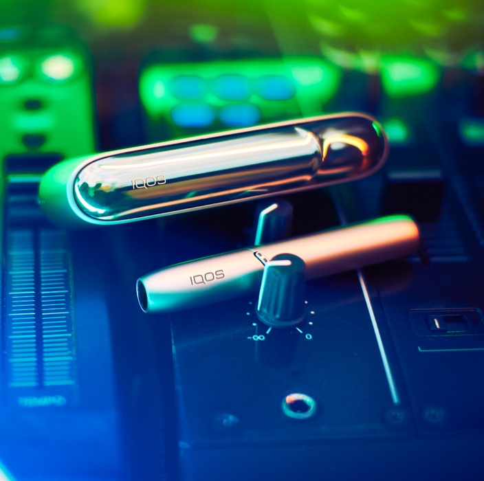 Brilliant gold IQOS 3 DUO holder and charger on a digital music production panel