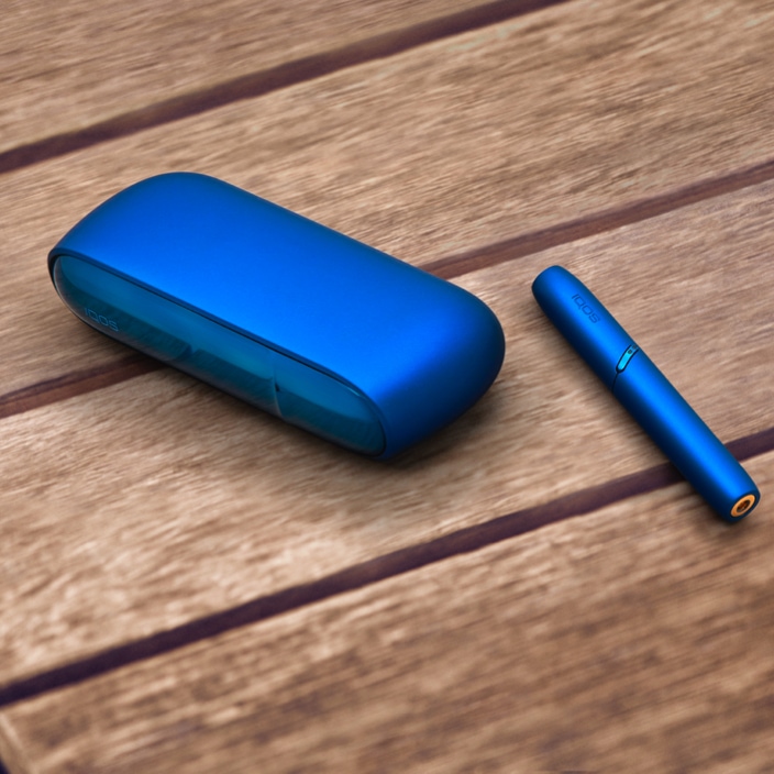 Stellar blue IQOS 3 DUO holder and charger on a picnic table