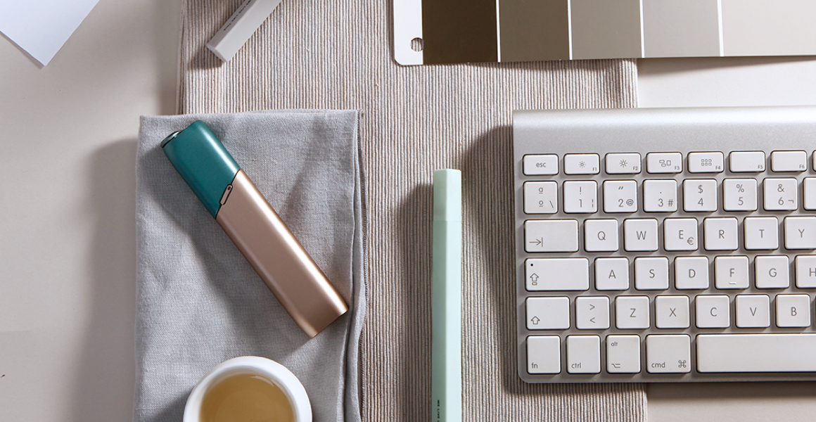 Green and coppery IQOS 3 MULTI kit on a working desk