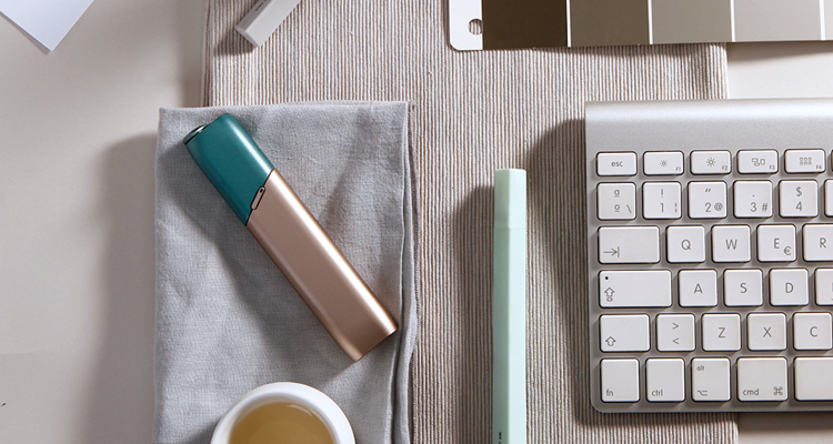 Green and coppery IQOS 3 MULTI kit on a working desk