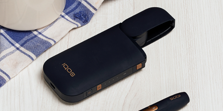 An unopened IQOS device box on a table.