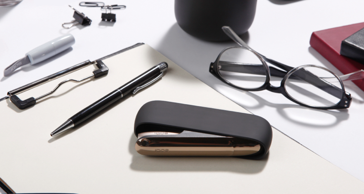 Black and silver IQOS 3 kit on a working desk