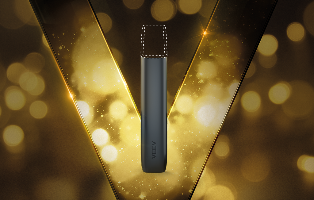 Imagem de um dispositivo VEEV ONE preto sobre um fundo preto com detalhes dourados.