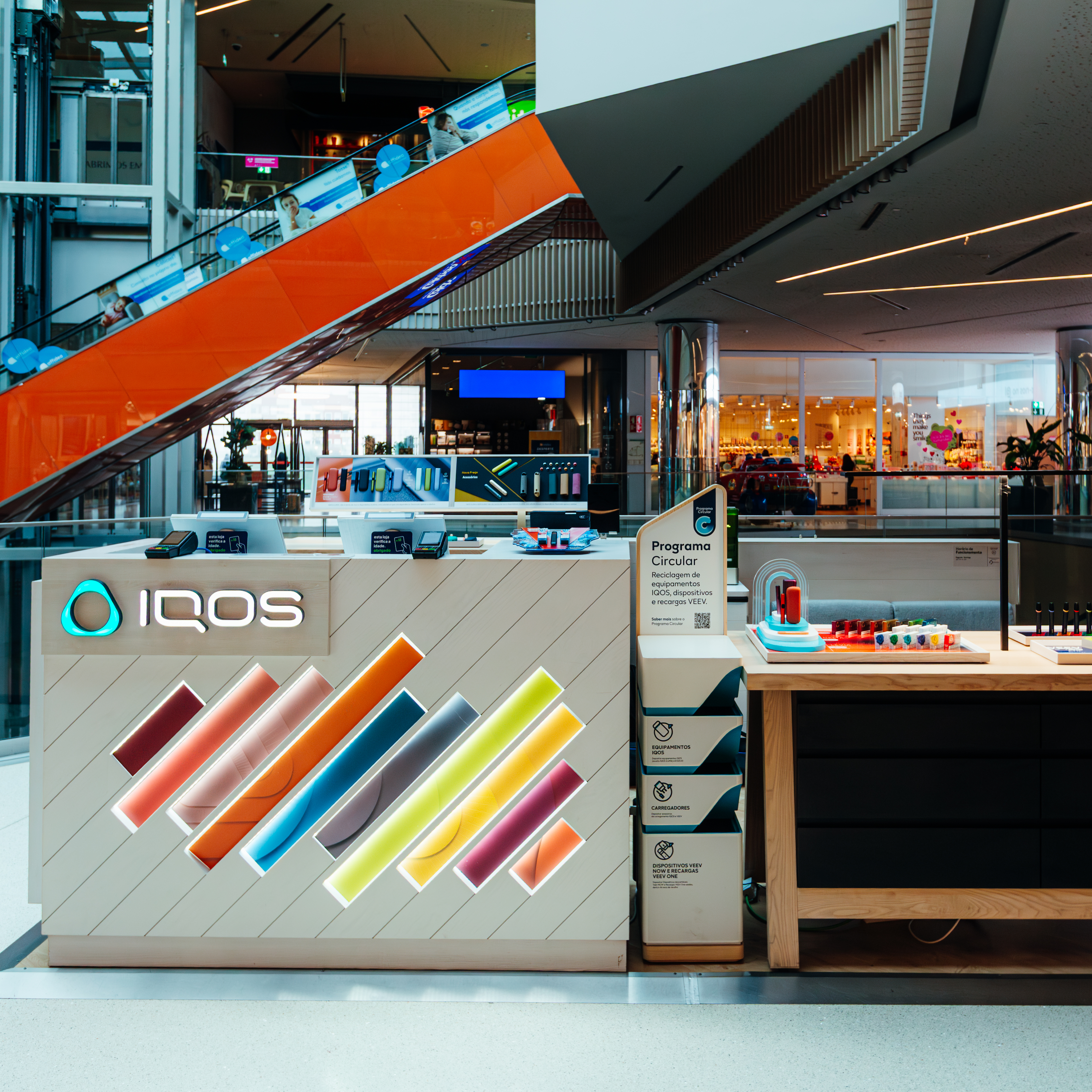 Um passaporte, um bilhete de avião e um equipamento IQOS numa mesa.
