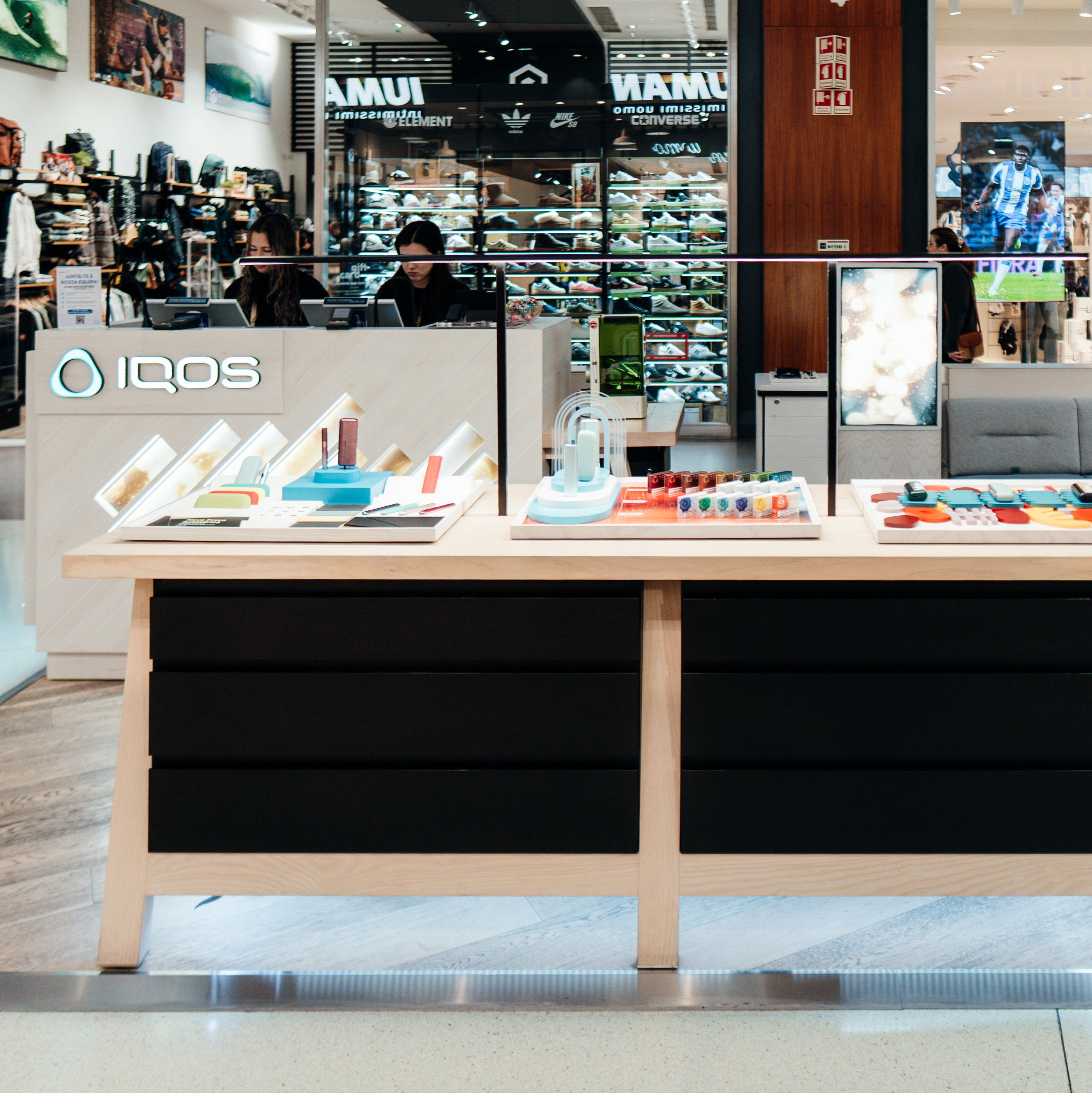 Um passaporte, um bilhete de avião e um equipamento IQOS numa mesa.